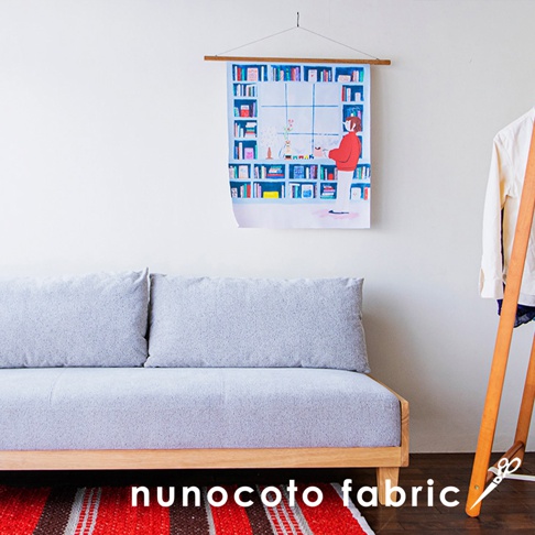 無框帆布藝術海報，描繪一幅室內場景，左側為淺灰色布質沙發，上方牆面懸掛著一幅畫作，畫中描繪一個書架，架上擺滿各式書籍，一位身穿紅色上衣、白色褲子的人物站在書架前。