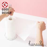 一隻手握著不鏽鋼立式紙巾架的頂部，另一隻手從架子上拉出一張白色紙巾。