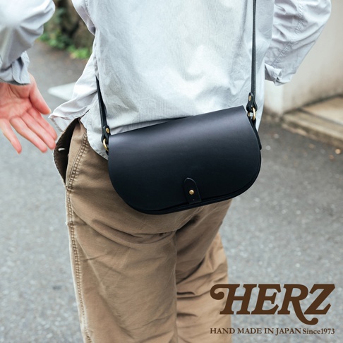 黑色皮革迷你馬鞍包，附有可調節的黑色皮革肩帶和金色金屬搭扣，由職人手工製作。