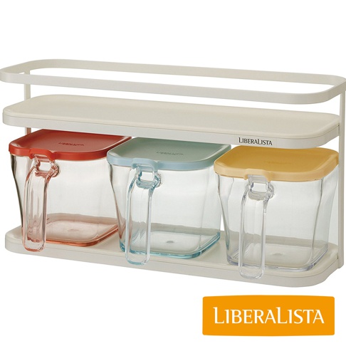 LIBERALISTA 白色調味料罐收納架，架上擺放著三個帶有把手的透明調味料罐，分別配有紅色、藍色和黃色的蓋子。
