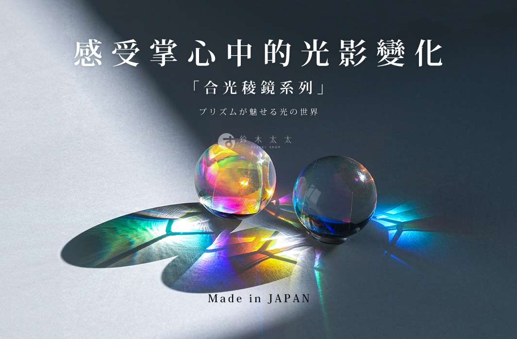 兩個透明的玻璃球，一個表面呈現彩虹般的光澤，另一個則是藍色調。它們被放置在白色背景上，並投射出七彩的光影。