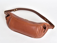 咖啡色皮革製成的大容量斜背包，有可調節的寬背帶，搭配金色金屬扣環和鉚釘，包身線條流暢，質感溫潤。