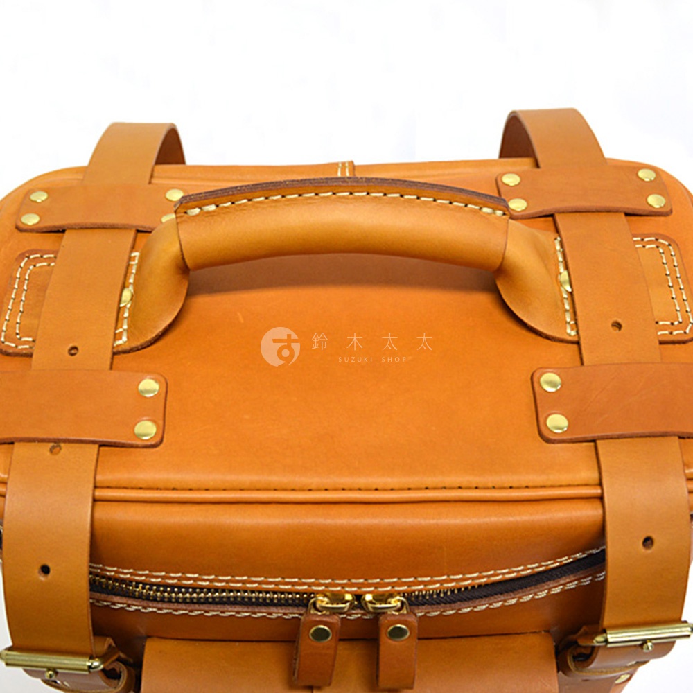 職人手作皮革大型三用旅行後背包，採用天然棕色皮革，配有皮質提把、金屬扣環和拉鍊，整體風格復古且堅固。