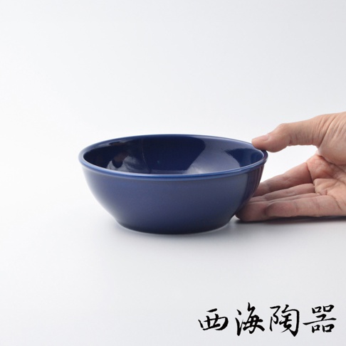 深藍色陶瓷料理深碗，有圓潤的碗身和細邊，由手持展示，展現其15公分的大小。