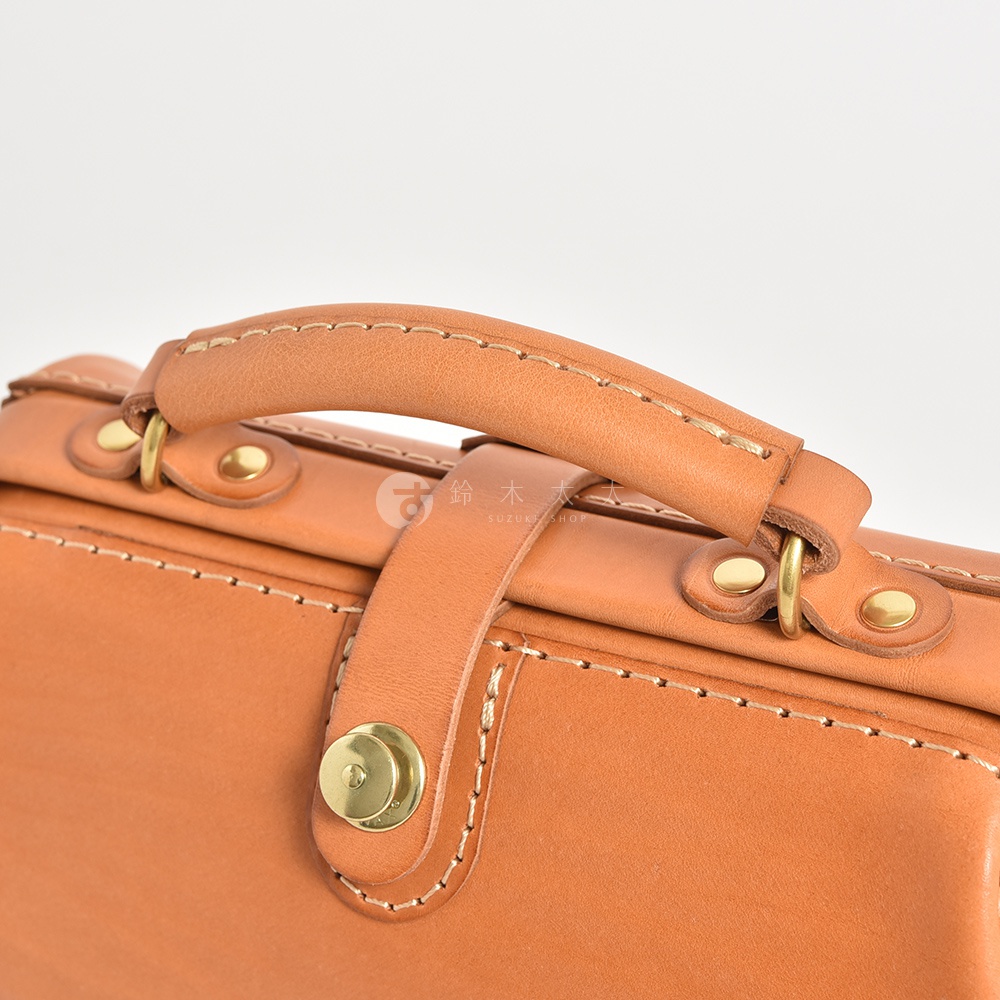 職人手作皮革口金醫生單肩包，採用鞣製皮革製成，配有同色系縫線的提把和金屬旋鈕。