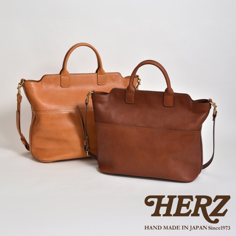 兩款職人手作皮革兩用托特包，分別為淺棕色與深棕色，材質皆為真皮。包款設計簡約，具備手提與肩背功能，整體呈現自然皮革質感。