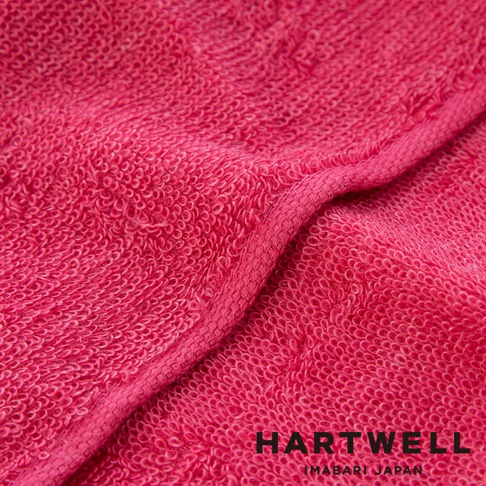 粉紅色毛巾特寫，織紋清晰可見，下方有 HARTWELL IMABARI JAPAN 字樣