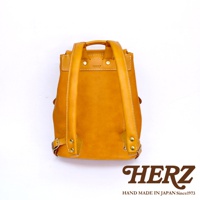 職人手作皮革多口袋後背包 R-135，芥末黃色，採用真皮材質，可見雙肩帶、頂部提把、金屬扣環及縫線細節，簡約設計。