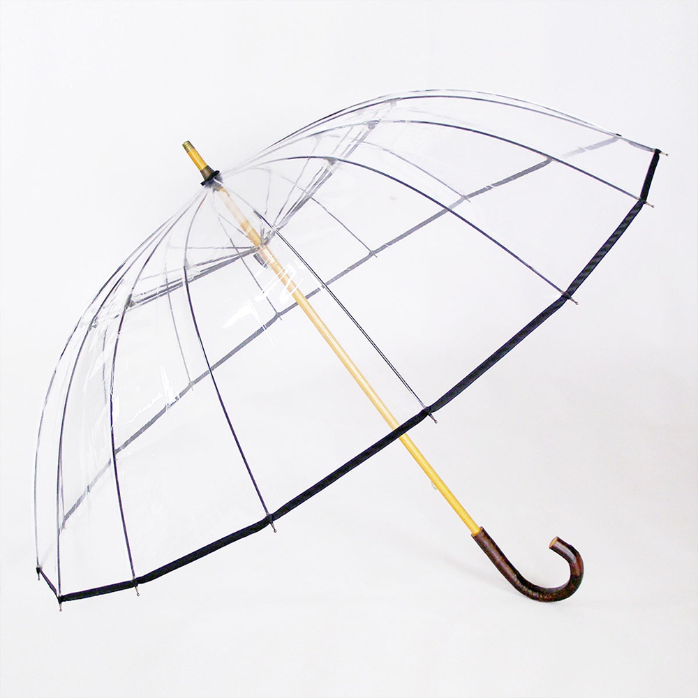 透明傘，傘面由透明材質製成，傘骨和傘柄為淺木色，傘柄末端為彎曲的深木色握把。