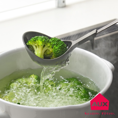 AUX leye 不沾桌多用濾水湯匙正在從沸水中撈起綠色的花椰菜，湯匙上有漏水孔。