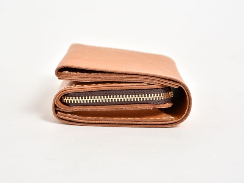 職人手作皮革中型雙折短夾，淺棕色天然皮革材質，搭配金色拉鍊，簡約設計，展現皮革紋理。