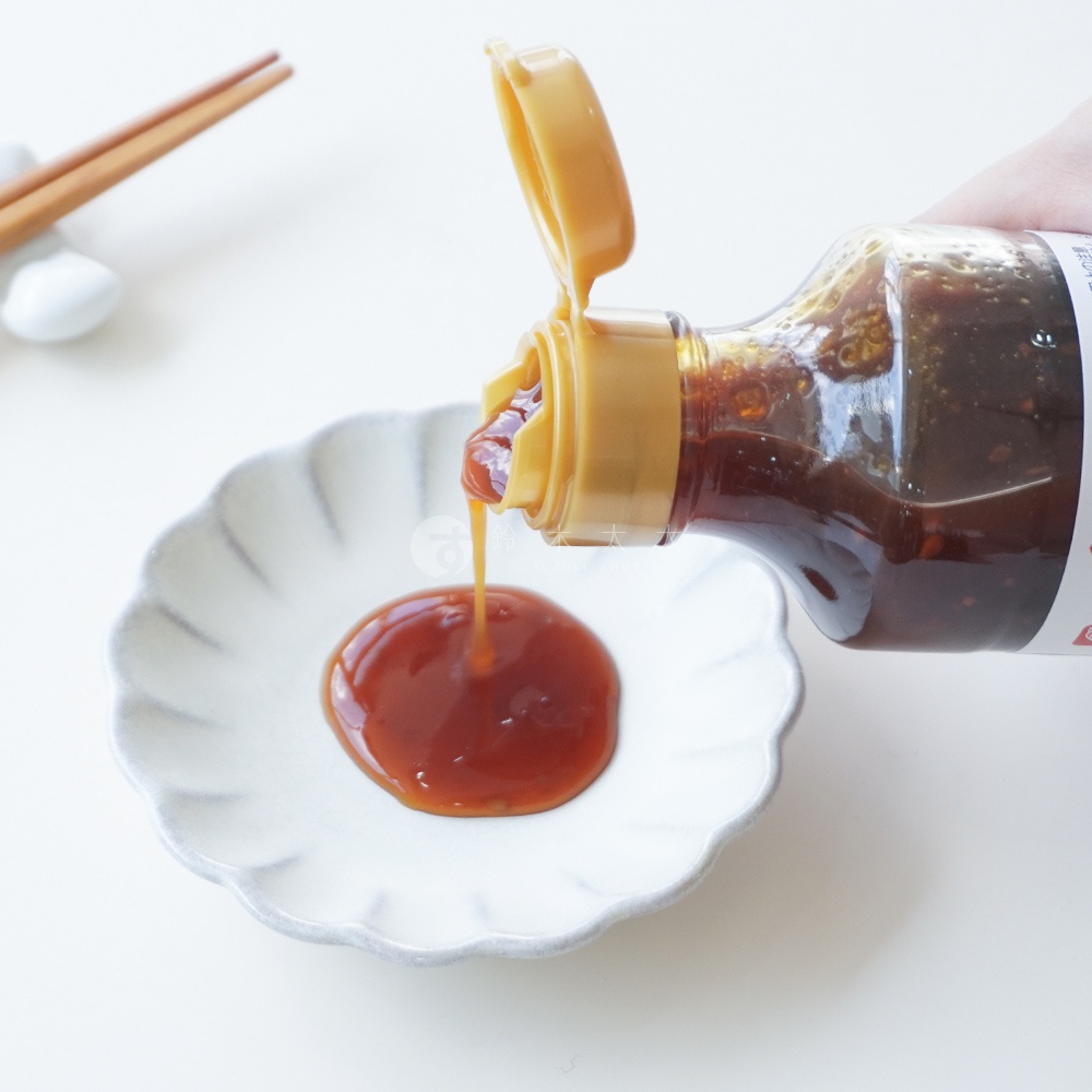 Bellfoods 北海道北見蘋果洋蔥風味調味醬從瓶中滴入白色貝殼狀小碟中