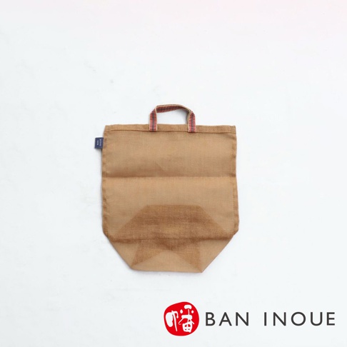 一個棕色麻質的提把收納袋，袋面有網狀透氣設計，提把為紅白色條紋織帶，袋旁有藍色小標籤。