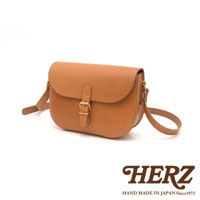 職人手作皮革經典馬鞍包，採用天然棕色皮革製成，配有黃銅色皮帶扣和可調節肩帶，風格簡約。