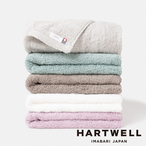 疊放的 CUOL 今治柔彈美肌毛巾，共六種顏色：淺灰、薄荷綠、淺棕、白色、淡紫色，以及最上方一條帶有品牌標籤的淺灰色毛巾。