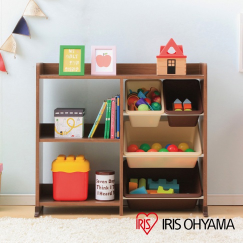 木質兒童玩具收納架，展示有綠色與粉色相框、書籍、玩具收納盒，內含積木、球類等玩具，以及紅色與黃色組合的積木形狀收納箱。