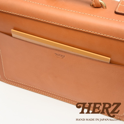 職人手作皮革機師箱 BC-31，採用 tan 色皮革製成，箱面有縫線細節，並設有可插入筆記本的外部口袋。