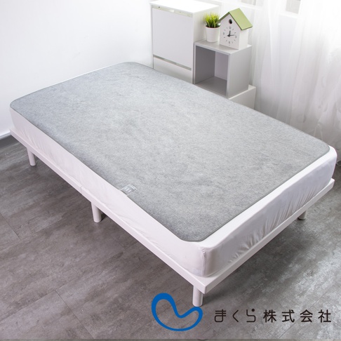 單人備長炭防潮床墊，灰色，鋪設在白色床架上，床墊材質觸感柔軟，邊緣有細緻的滾邊，整體呈現簡約的居家風格。