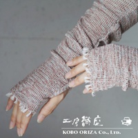 一雙粉紅色與灰白色交織的輕柔有機棉遮陽袖套，袖口有流蘇裝飾，展示於人手上。