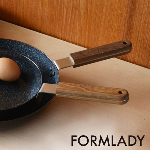 日製 ambai 小泉誠原木柄平底鐵鍋，鍋身黑色，鍋柄為木紋材質，鍋內有一個褐色雞蛋。