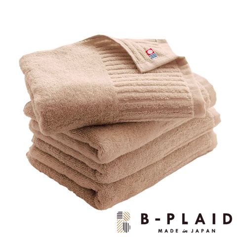 堆疊的米色 RIB 今治浴巾，材質柔軟，表面帶有直條紋織紋，頂端浴巾角落有品牌標誌。