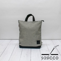 三河木綿刺子織手提後背包，以黑白格紋圖案為主體，搭配黑色底部與提把，側面有一個黑色方形布標。