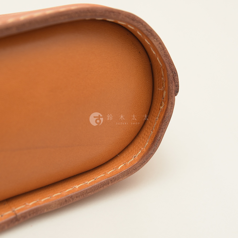 職人手作皮革三角收納包，展示淺棕色皮革內襯與深棕色皮革外緣，縫線清晰。