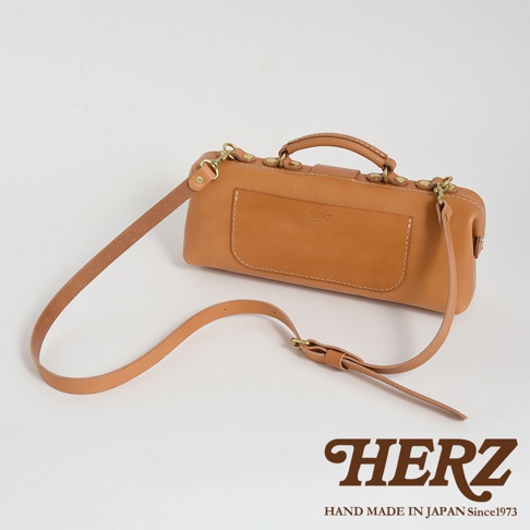 日本HERZ職人手作皮革橫長形杜勒斯單肩包，駝色軟皮革材質，附可拆式調整肩背帶，包身有品牌標誌與手縫細節。