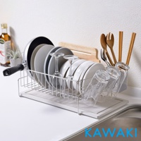 銀色金屬網架，收納有平底鍋、數個灰色與白色圓盤、兩個高腳杯、四個玻璃杯，以及木製餐具組。下方有一塊米白色珪藻土吸水墊。