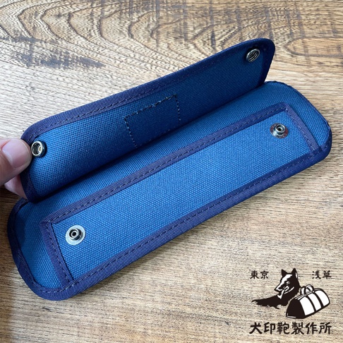 這款黑犬印純綿帆布肩墊採用深藍色，材質為純綿帆布，設有金屬釦子，可用於保護肩部。