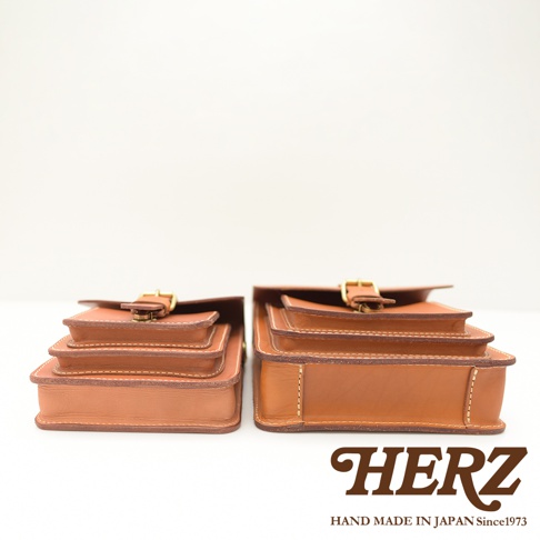 兩只職人手作皮革單肩兩用小方包，呈現棕褐色，搭配金屬釦帶，展現經典復古風格。