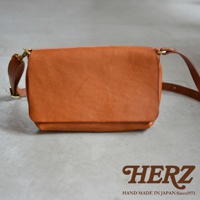 經典棕色皮革斜背包，簡約翻蓋設計，搭配金屬扣環與細緻背帶，呈現職人手作質感。