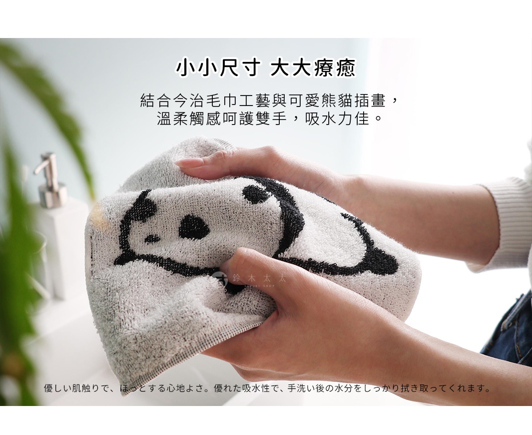 兩隻手拿著一條印有熊貓圖案的白色毛巾