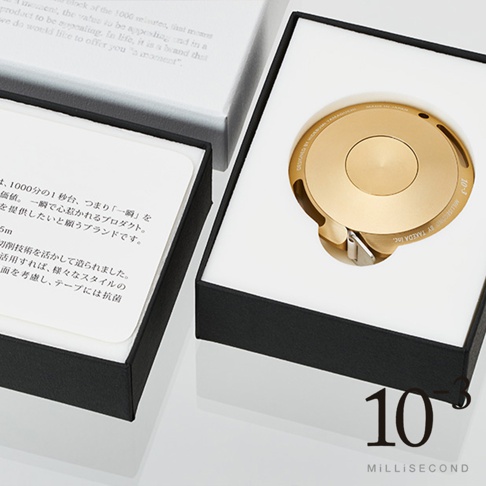 金色鋁製卷尺，圓形外殼，精緻設計，收納於黑色包裝盒內，旁邊附有產品說明卡。