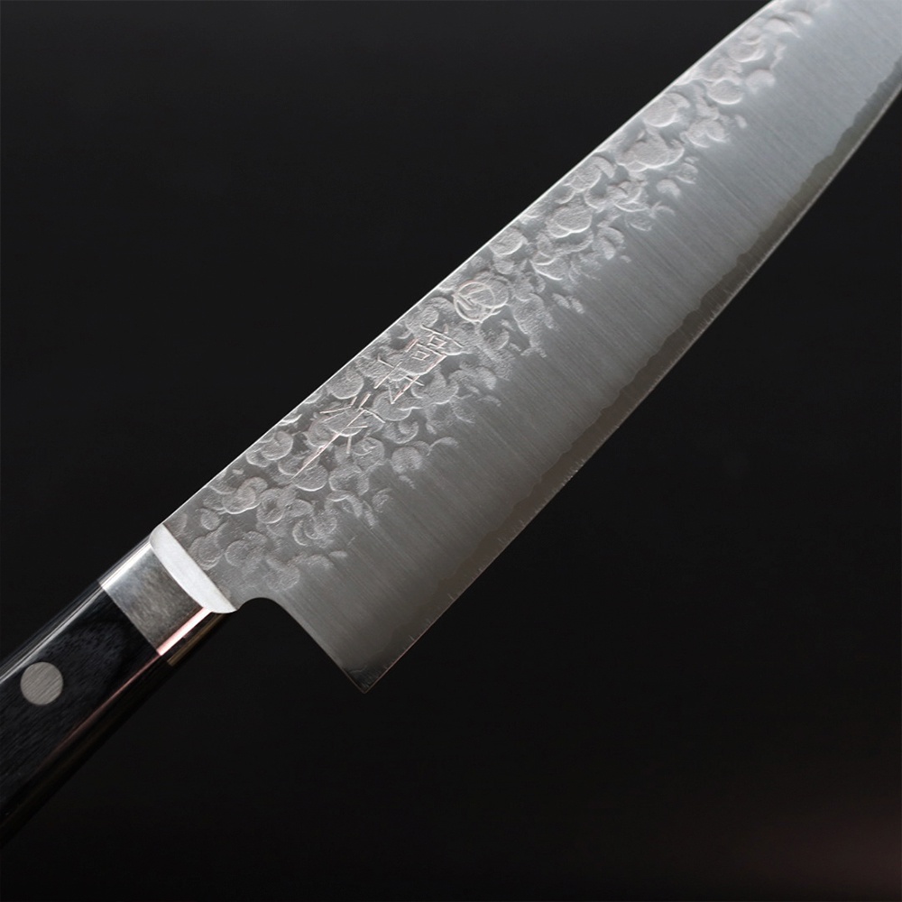 VG10不鏽鋼鎚紋牛刀，18公分刀刃，具有獨特的鎚目紋理，銀色刀身，黑色刀柄。