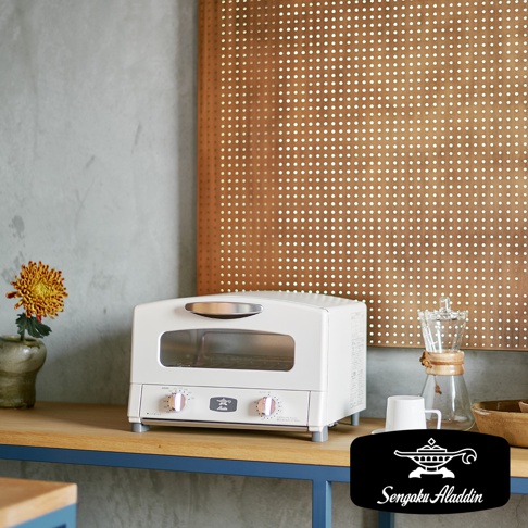 白色復古多用途烤箱，配有兩個旋鈕和一個銀色把手。烤箱正面有兩個玻璃窗，可見內部烤架。