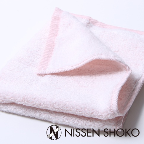 粉紅色柔軟毛巾，材質為棉，帶有編織邊緣。