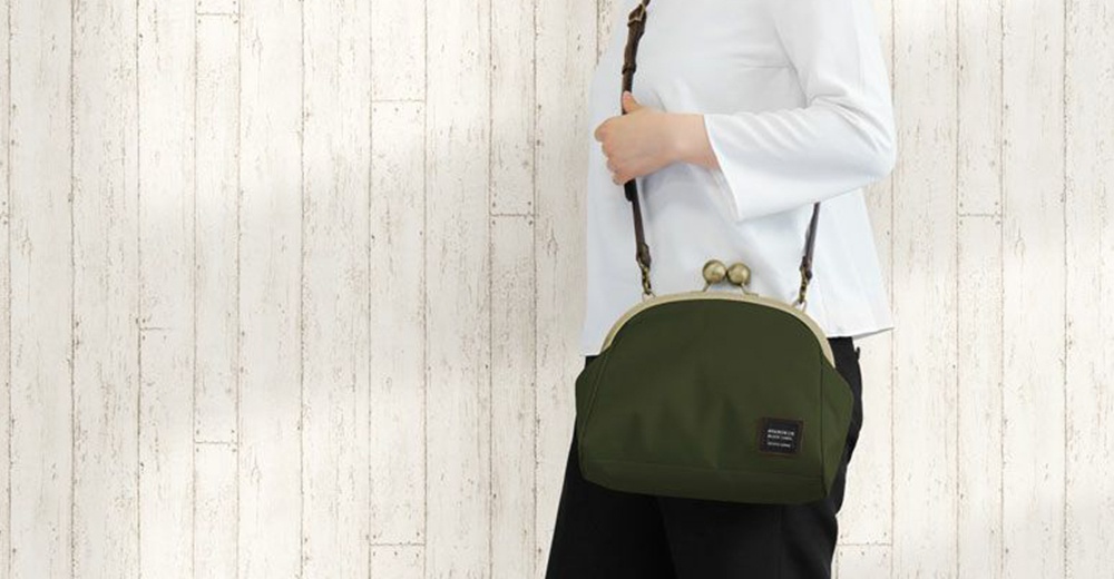 京都職人手作大玉口金斜背包，採用深綠色CORDURA®材質，配有古董金色的口金和肩帶零件，適合日常外出攜帶。
