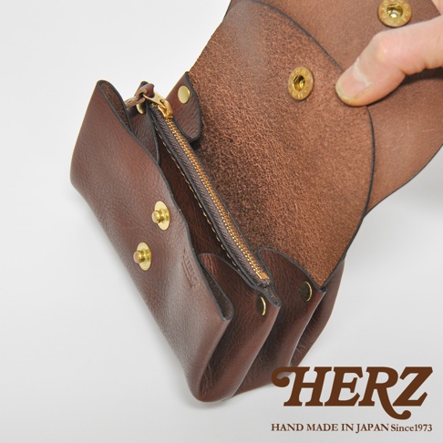 職人手作皮革三層收納零錢包，深棕色皮革，設有金色拉鍊與按扣，內部為淺棕色皮革，展示產品的材質與結構。