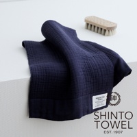 深藍色雙面紗布輕質毛巾，材質為棉，表面有紋理，一角有品牌標籤。