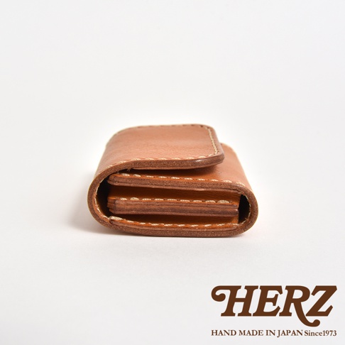 側面視角的日本HERZ職人手作Stare皮革雙折零錢包，呈現焦糖棕色澤與精緻手工縫線細節，設計簡約且結構紮實。