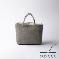 一款黑白格紋三河木綿刺子織托特包，配有米色內襯和提把。