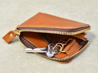 棕色皮革製作的拉鍊卡片鑰匙包，內有銀色金屬鑰匙和鑰匙圈。包包採用全包式拉鍊設計，拉鍊為深棕色，金屬部分為金色。