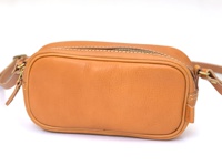 職人手作的棕褐色皮革小方包，設有拉鍊開合和可調節的皮革肩帶，包身線條簡潔，皮革表面帶有自然紋理。