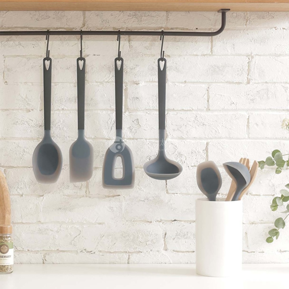 日系風格廚房，懸掛著一系列灰色矽膠鍋鏟，與一旁的白色收納筒內的木質料理工具及矽膠漏勺形成對比。
