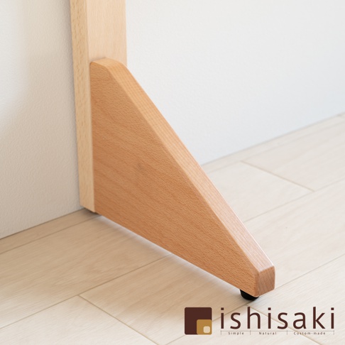 木製兒童多功能繪畫白板的支架，採用淺木色櫸木材質，呈現三角形支撐結構，底部帶有黑色小輪，與淺木紋地板和白色牆壁背景形成對比。