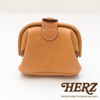 職人手作皮革口金化妝包 KF-143 M，採用天然皮革材質，呈現焦糖棕色調，設計簡約，帶有經典的口金開合與皮革裝飾細節。