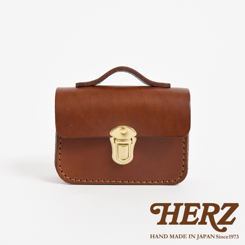 職人手作皮革迷你收納包，經典棕色，採用天然皮革製作，配有黃銅鎖扣和提把，車縫線整齊，風格復古。