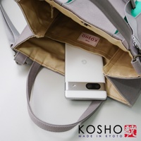 灰色棉帆布托特包，內襯為卡其色，展示包包內部空間，一個白色手機置於其中。