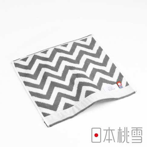 今治北歐方巾，灰色與白色相間的鋸齒紋圖案，材質為棉，觸感柔軟，帶有品牌標籤。